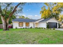 Charming single-story home nestled on a spacious lot with a lush lawn and mature trees at 1704 Ison Ln, Ocoee, FL 34761