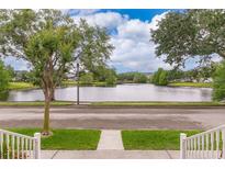 Scenic view of a serene lake, trees, and blue skies from the front porch of this charming home at 5342 Horton Ln, Orlando, FL 32814