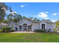 Charming single-story home featuring a brick driveway, well-manicured lawn, and lush landscaping at 571 Masalo Pl, Lake Mary, FL 32746