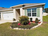 One-story home with landscaped yard and two-car garage at 524 Boardwalk Ave, Haines City, FL 33844