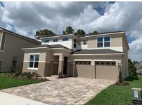 Two-story home with a two-car garage and a beautiful brick driveway and front lawn at 9271 Patrimonio Loop, Windermere, FL 34786