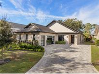 Modern single-story home with stone accents and a paver driveway at 10214 Chiltern Garden Dr, Orlando, FL 32827