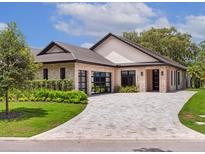 Stunning single-story home with a stone and siding exterior, complemented by a well-manicured front yard and circular driveway at 10214 Chiltern Garden Dr, Orlando, FL 32827