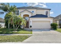 Inviting two-story home with a two-car garage and well manicured front lawn at 14112 Morning Frost Dr, Orlando, FL 32828