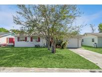Charming single-story home with a well-manicured lawn and mature tree, offering curb appeal at 1603 Doreen Ave, Ocoee, FL 34761