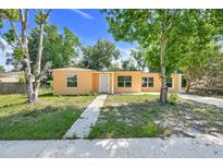 Front exterior of home featuring large front windows, a walkway and lawn at 2341 Hadley St, Deltona, FL 32738