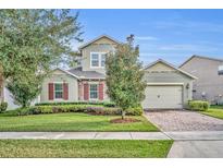 Two-story house with stone accents and a landscaped lawn at 14157 Creekbed Cir, Winter Garden, FL 34787