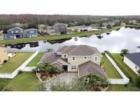 Stunning lakefront property with manicured lawn, paver driveway and mature palms in an attractive neighborhood at 3301 Buckingham Way, St Cloud, FL 34772