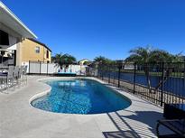 Backyard swimming pool with a view of the lake and palm trees, and outdoor seating at 3301 Buckingham Way, St Cloud, FL 34772