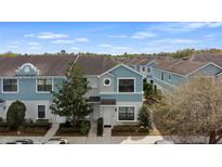 Beautifully designed two-story townhome with a blue and light stucco exterior, showcasing the front yard and landscaping at 1161 Trillium Park Ln, Sanford, FL 32773