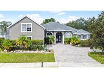 Two-story house with gray siding, paver driveway and landscaping at 1424 Richmond Grand Ave, Orlando, FL 32820