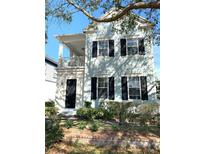 Two-story light blue house with black shutters, a front porch, and landscaping at 3929 Corrine Dr, Orlando, FL 32814