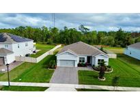 Charming single-story home with a well-manicured lawn, garden beds, and a brick paver driveway at 4223 Sunset Preserve Blvd, Orlando, FL 32820