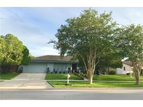 Charming single story home featuring a manicured lawn, lush landscaping, and an attached garage at 5138 Andrea Blvd, Orlando, FL 32807