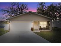 Charming single-Gathering home features a well-manicured lawn, attached garage, and a cozy front porch sitting area at 1208 Old Apopka Rd, Apopka, FL 32703