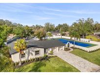 Stunning home features a tennis court, a patterned brick driveway, and a lush landscaped yard at 2337 Worthington Rd, Maitland, FL 32751