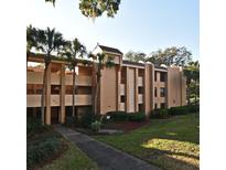 Tan multi-story condo building with palm trees and landscaping at 610 Cranes Way # 307, Altamonte Springs, FL 32701