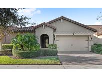 Single-story home with a tile roof, neutral color scheme, and a two-car garage at 10713 Berry Creek Rd, Orlando, FL 32836