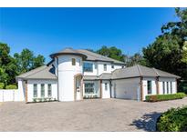 Two-story house with gray roof, white walls, and a large driveway at 5049 Lake Howell Rd, Winter Park, FL 32792