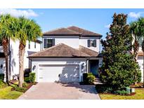 Charming two-story home featuring a well-manicured front yard, brick driveway and attached two car garage at 1219 Verdant Glade Pl, Winter Park, FL 32792