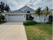 House exterior featuring a two-car garage and well-manicured lawn at 1193 Sable Key Cir, Port Orange, FL 32128