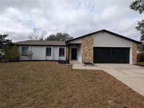 Updated single-story home with a stone accent and a two-car garage at 1860 Gladiolas Dr, Winter Park, FL 32792