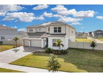 Two-story house with solar panels, three-car garage, and landscaped yard at 4360 Sunset Preserve Blvd, Orlando, FL 32820