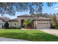 Beautiful one-story home with tile roof, landscaping, and two-car garage at 9918 Santa Barbara Ct, Howey In The Hills, FL 34737