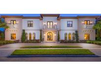 Elegant two-story home with a grand entrance and manicured lawn at 1261 Radiant St, Reunion, FL 34747