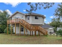 Elevated home with wrap-around deck, detached garage, and RV parking at 1399 Old Mount Dora Rd, Eustis, FL 32726