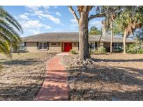 Front entrance of a ranch-style house with red door and a walkway at 1265 Lake Francis Dr, Apopka, FL 32712