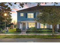 Two-story townhome with light blue exterior, landscaping, and front porch at 15322 Murcott Blossom Blvd, Winter Garden, FL 34787