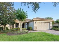 Single-story home with tile roof, stone accents, and two-car garage at 307 Monterey St, Kissimmee, FL 34759