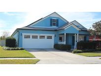 Light blue two-story house with white garage door and landscaping at 515 Haywood Ln, Lake Alfred, FL 33850