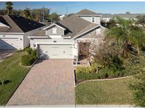 Two-story home with a paver driveway and landscaped yard at 1722 Farmstead Ln, Oviedo, FL 32765