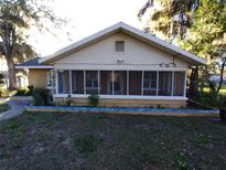 One-story house with screened porch and small landscaped yard at 201 N East St, Leesburg, FL 34748