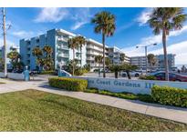 Sea Coast Gardens II building exterior, featuring palm trees and ample parking at 4153 S Atlantic Ave # 3070, New Smyrna Beach, FL 32169