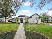 Beautiful one-story home with a lush lawn and brick pathway at 4520 Old Carriage Trl, Oviedo, FL 32765