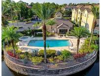 Resort-style pool with clubhouse, lush landscaping, and serene lake views at 4849 Cypress Woods Dr # 1310, Orlando, FL 32811