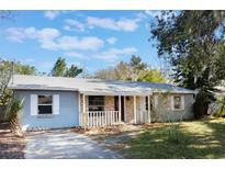 Light blue house with a covered porch and manicured lawn at 540 Fern Ave, Tavares, FL 32778