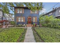 Charming two-story home with a well-manicured lawn, wood shutters, and a welcoming red front door at 606 E Amelia St, Orlando, FL 32803