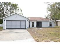 Gray house with attached garage and a spacious front yard at 741 Caribou Dr, Kissimmee, FL 34759