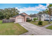 Cute pink house with a two-car garage and well-maintained lawn at 9606 Chandon Dr, Orlando, FL 32825