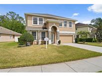 Charming two-story home featuring stone accents, a well-manicured lawn, and a welcoming front entrance at 10097 Leland Dr, Orlando, FL 32827