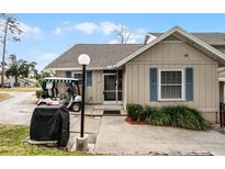 Tan house exterior with golf cart and grill at 1339 Villa Ln # 50, Apopka, FL 32712