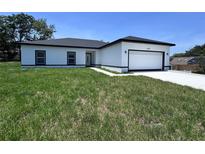 Charming single Gathering home with a crisp white exterior, black accents, and an attached two-car garage at 1608 Airmont Ave, Deltona, FL 32725