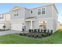Charming two-story home with a two-car garage, manicured lawn, and stone accents in a sunny neighborhood at 1914 Summer Serenity Dr, Kissimmee, FL 34744