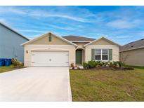 Single-story house with a two-car garage and landscaped lawn at 1213 Red Hill Rd, Davenport, FL 33837