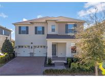 Two-story house with gray shutters, two-car garage, and a brick driveway at 16685 Oakboro St, Winter Garden, FL 34787