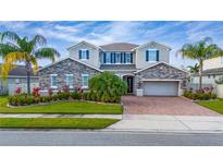 Two-story house with stone accents and a three-car garage at 6011 W Town Center Blvd, Orlando, FL 32837